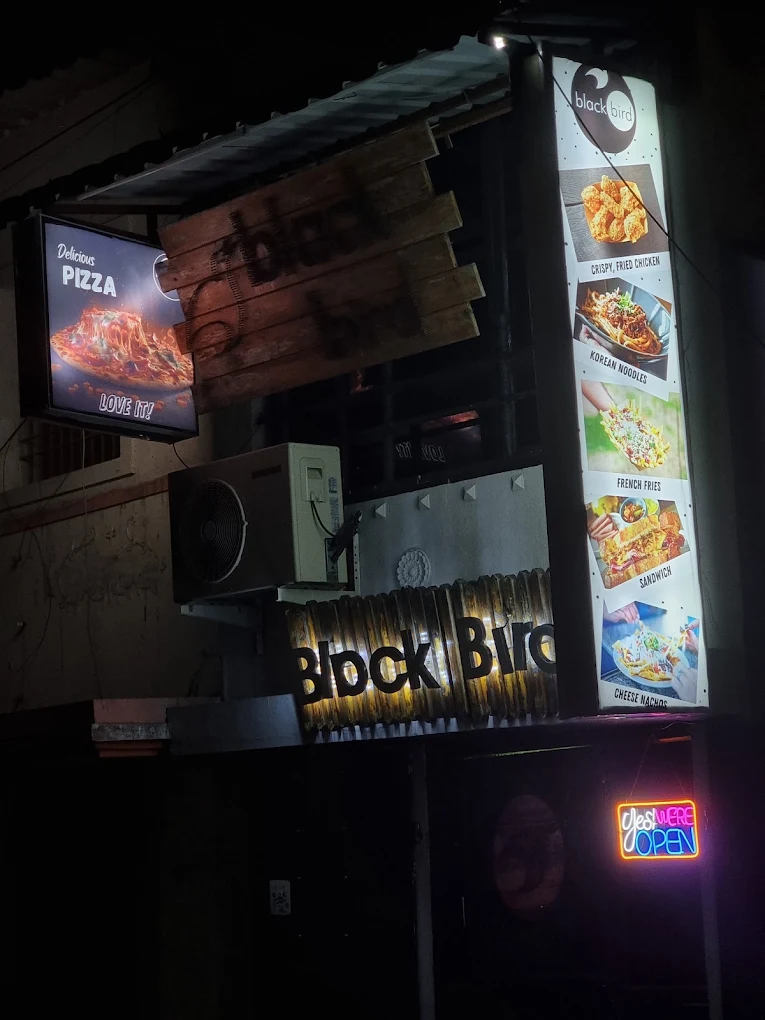 Illuminated menu boards showing pizzas and combo meals above the takeaway counter