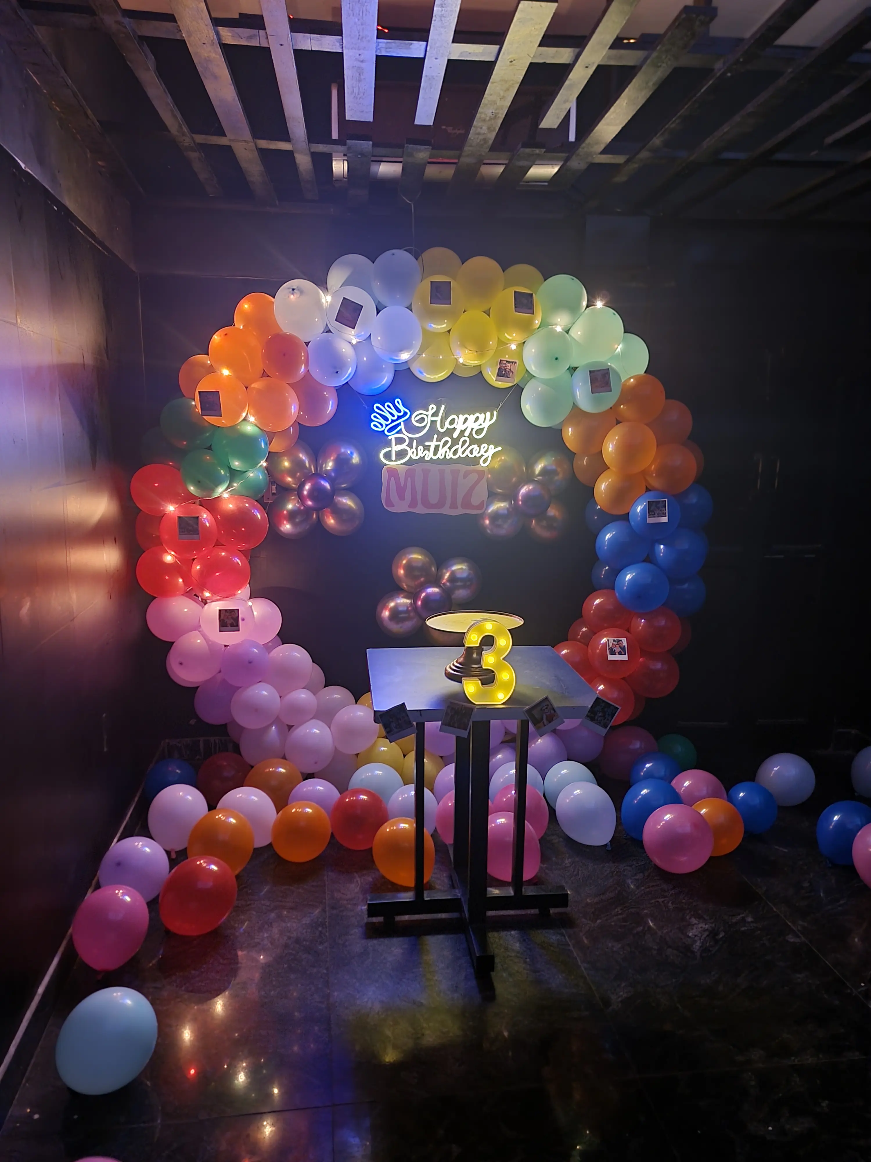 Birthday setup inside the café, with a balloon arch and a lit Happy Birthday sign