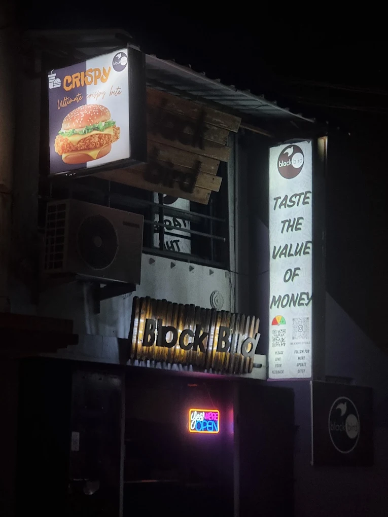 The Black Bird Cafe & Restaurant storefront lit up at night in Vellore
